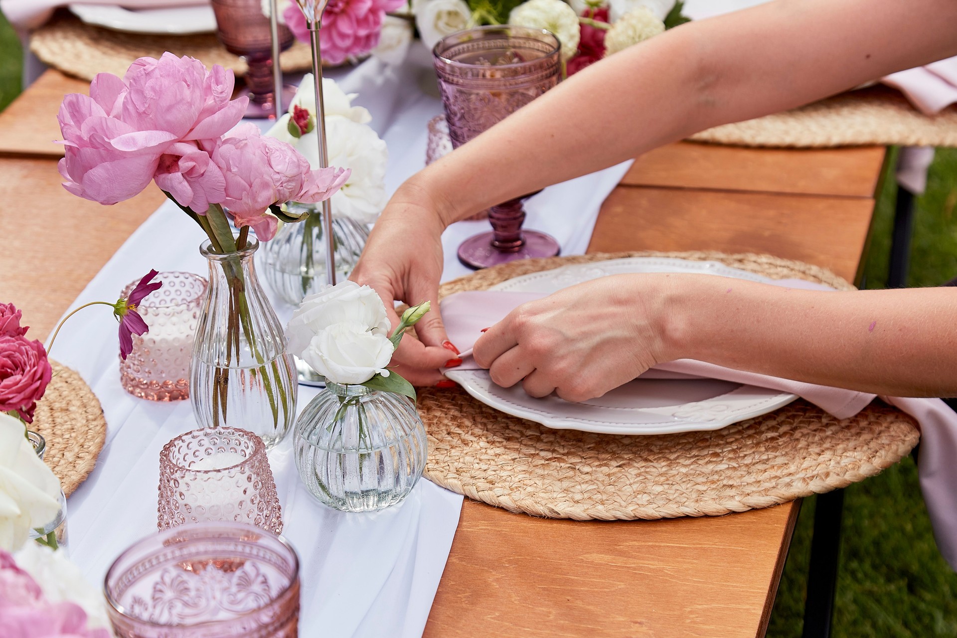 Elegant outdoor table setting with pink peonies. Wedding reception and event planning themes