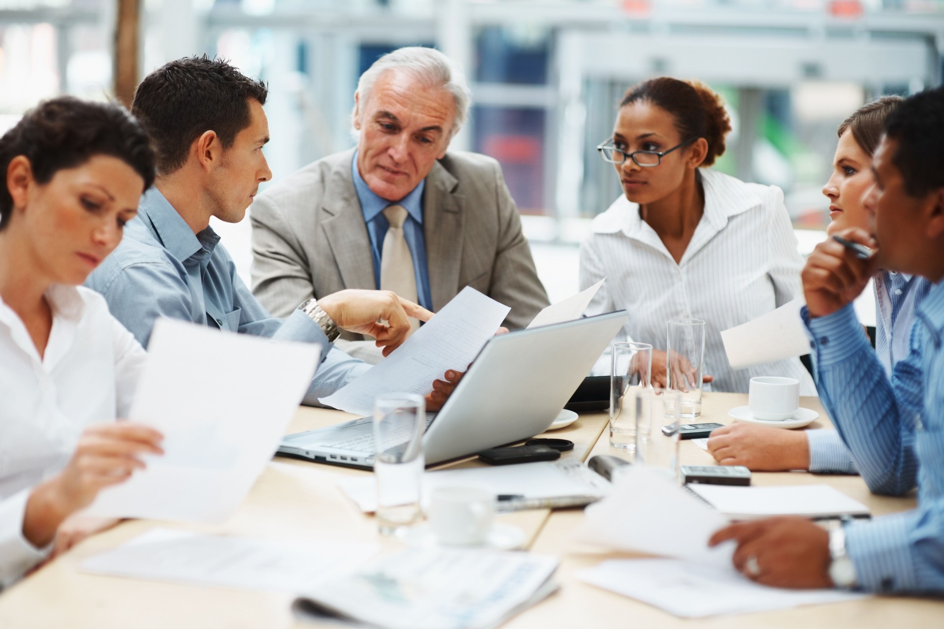 Business people discussing work on laptop at a meeting